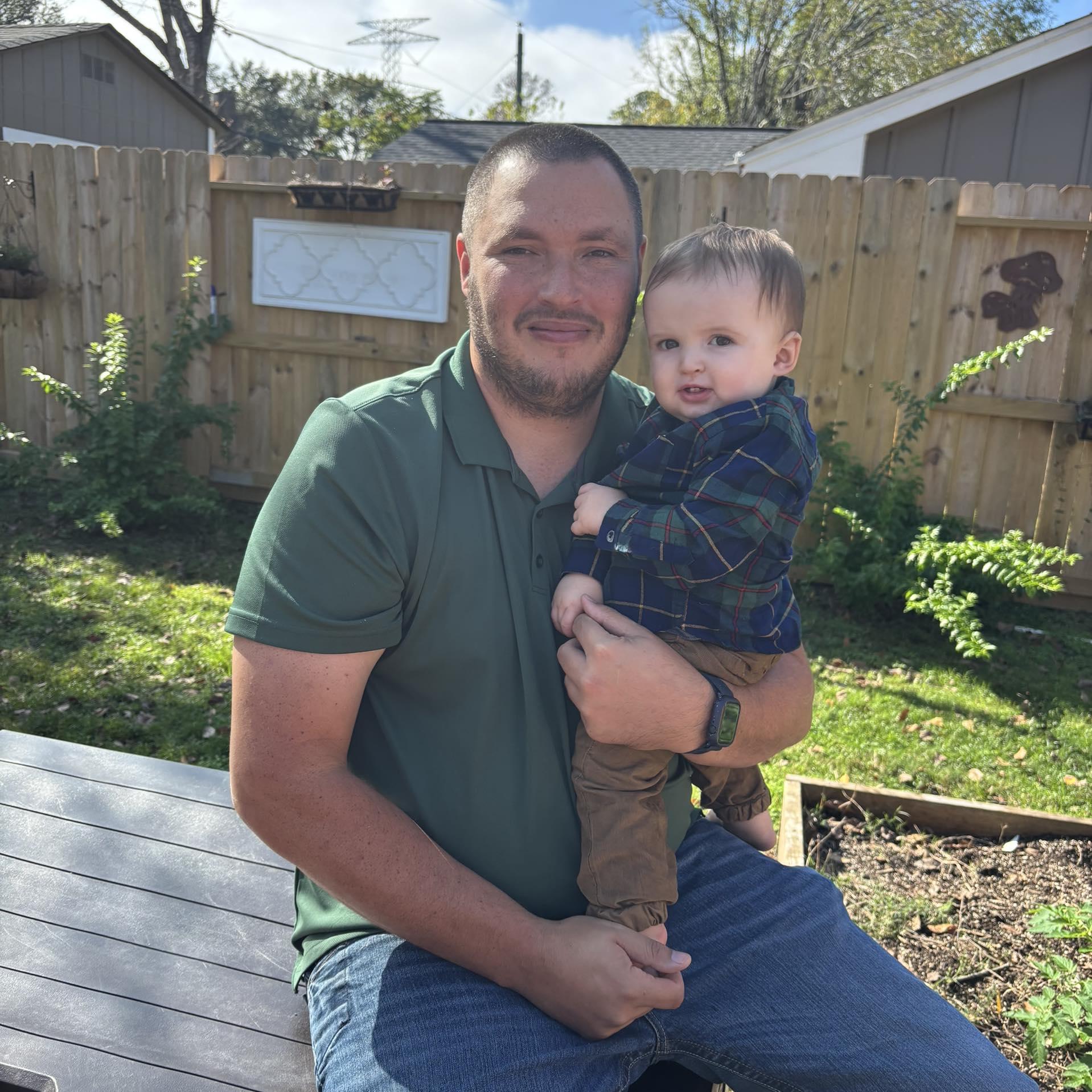 Andrew, founder of Sam Houston Pools and Outdoors, with his son in their Lovelady, TX backyard